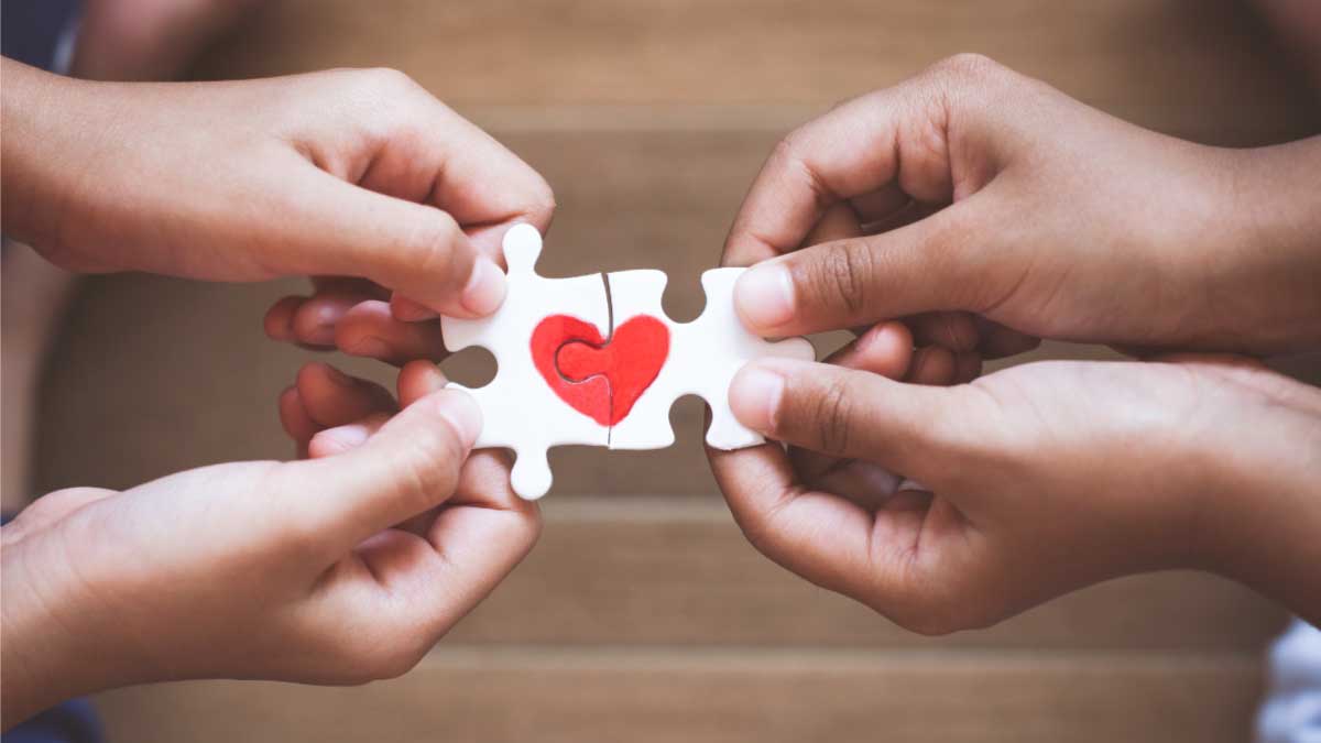 hands holding puzzle with heart